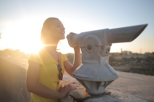 Woman Looking in a Gray Telescope during Sunset