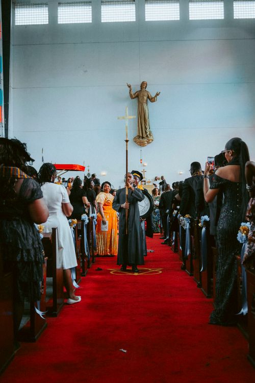 Free A vibrant ceremonial procession inside a Monrovia church with people gathered and ornate decorations. Stock Photo