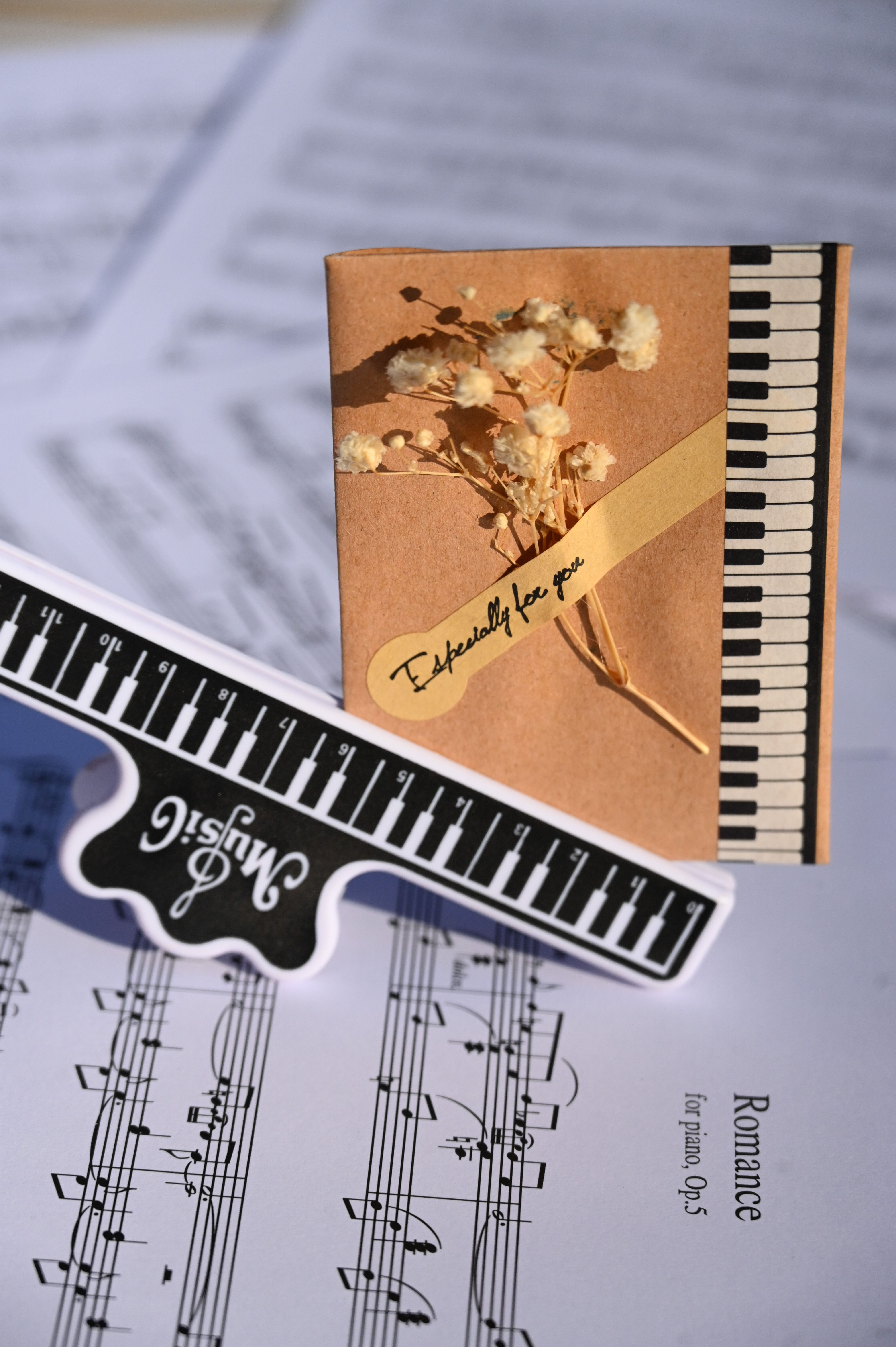 A creative greeting card with piano keys, sheet music, and floral art, conveying a musical message.