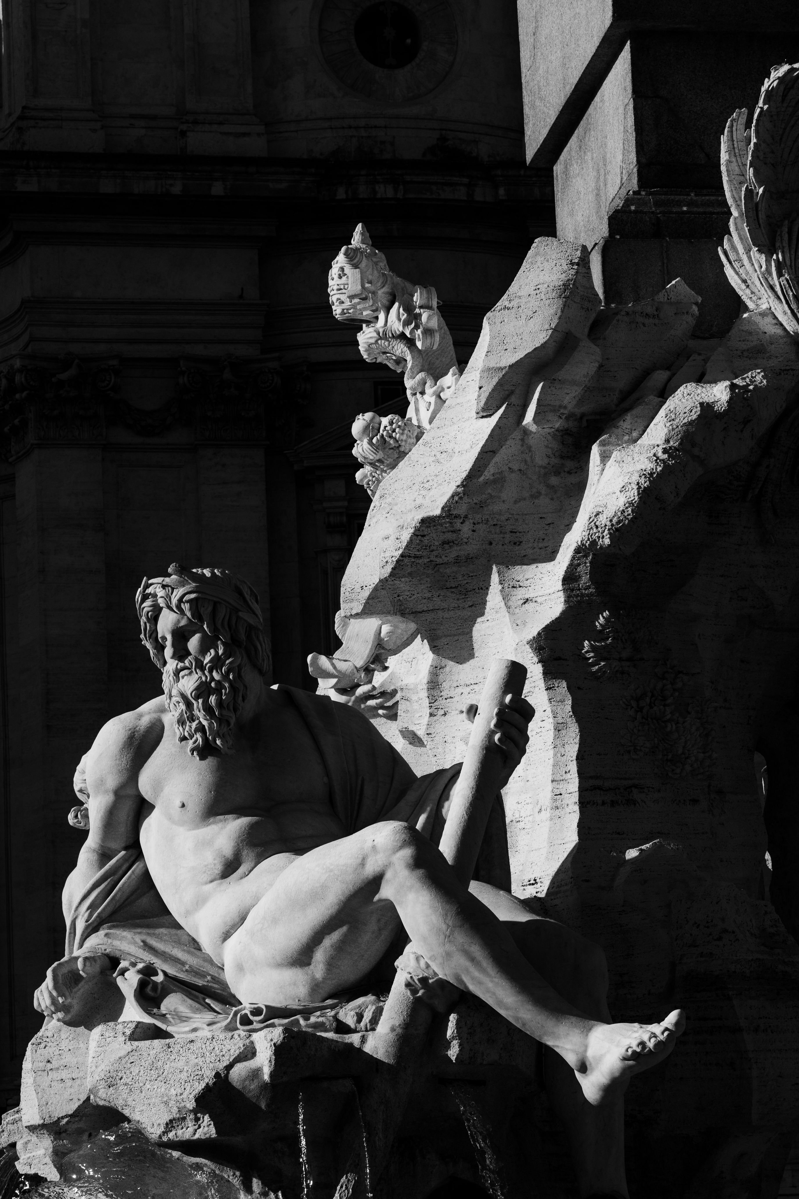 Black and white photo of a Rome fountain statue with dramatic lighting.