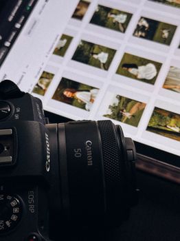 DSLR camera next to a digital screen displaying photographs in an editing software.