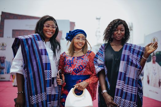 Group of women in colorful traditional African clothing enjoying an outdoor event.