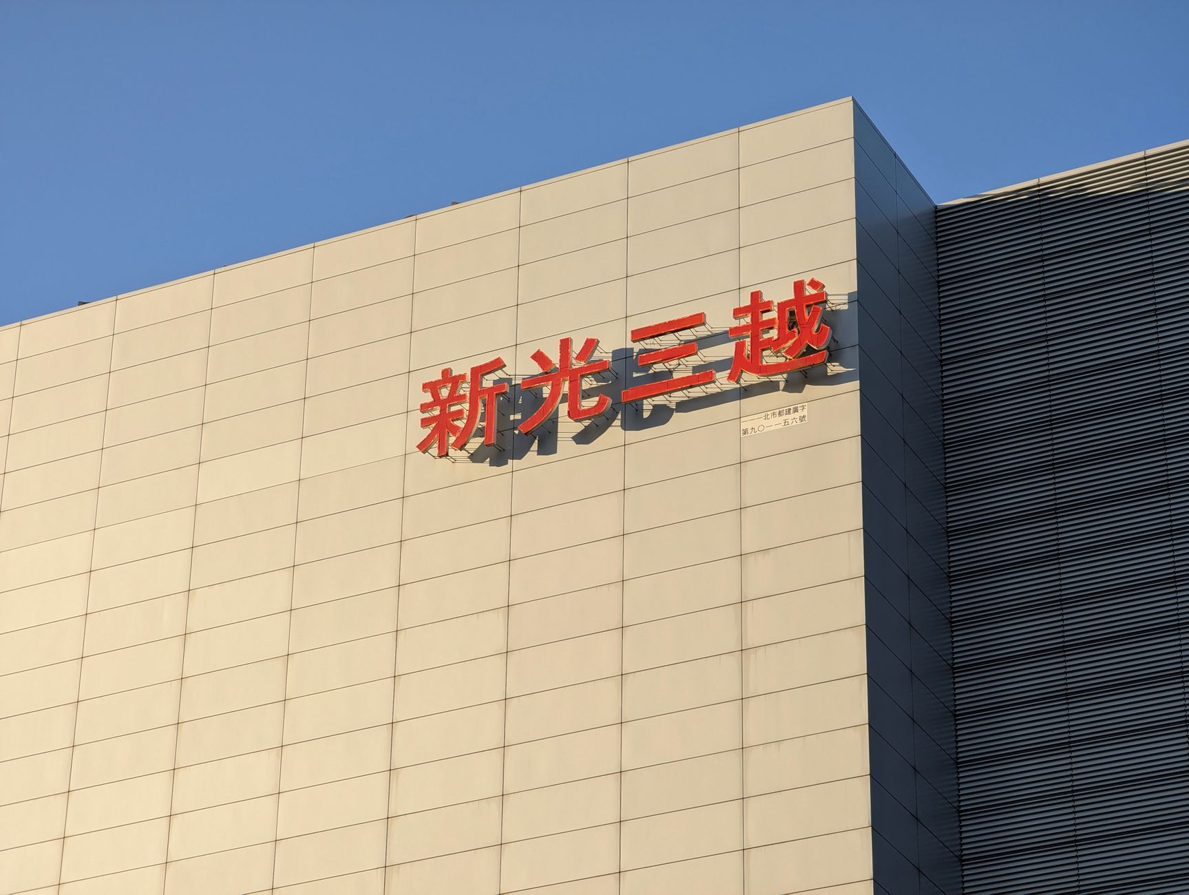 Exterior view of a modern commercial building in Taipei featuring distinctive Chinese signage.