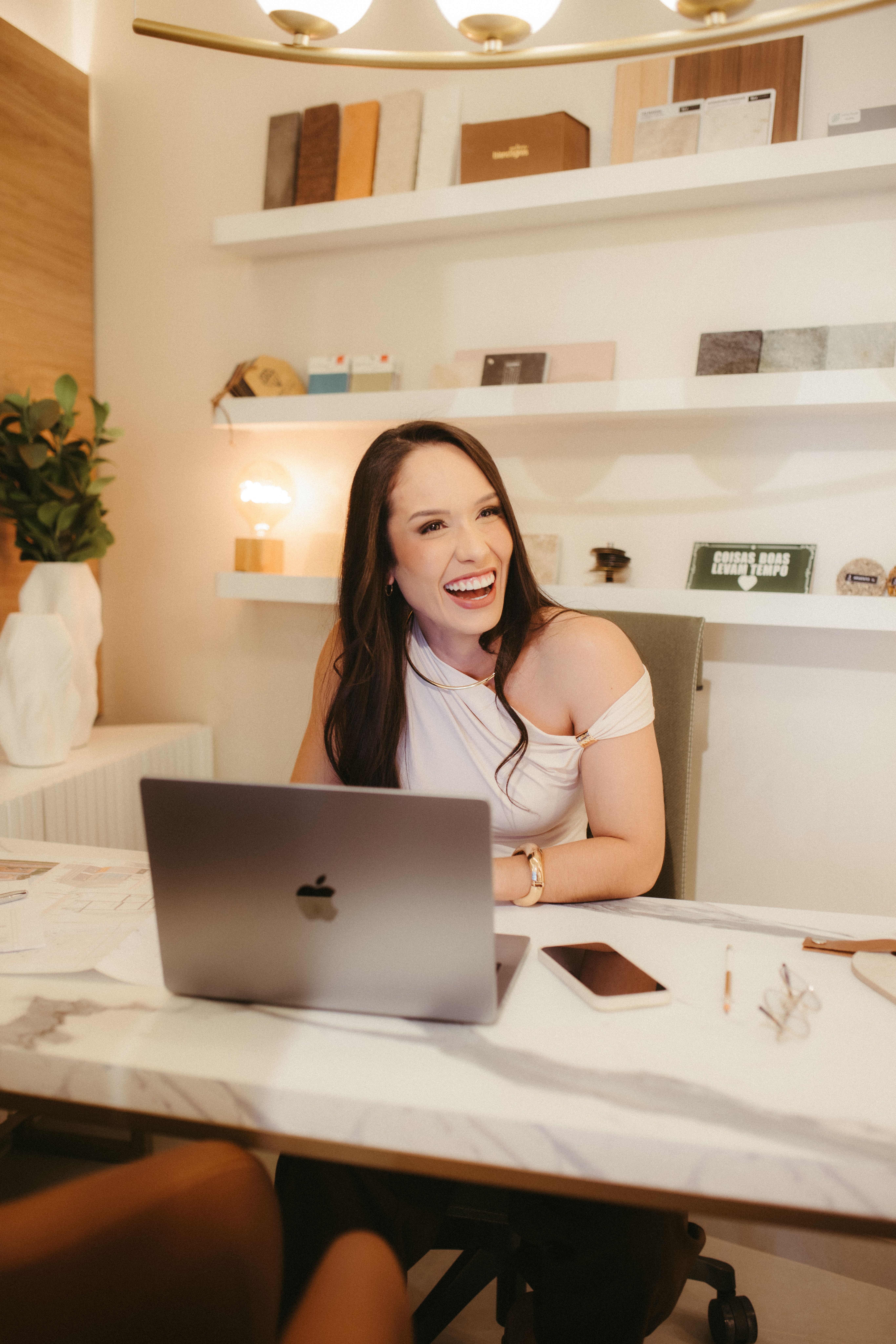 Maya Chen smiling while working on a laptop in a modern home office