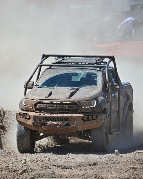 Free A powerful off-road truck kicks up dust during an intense desert race, showcasing its strength and resilience. Stock Photo