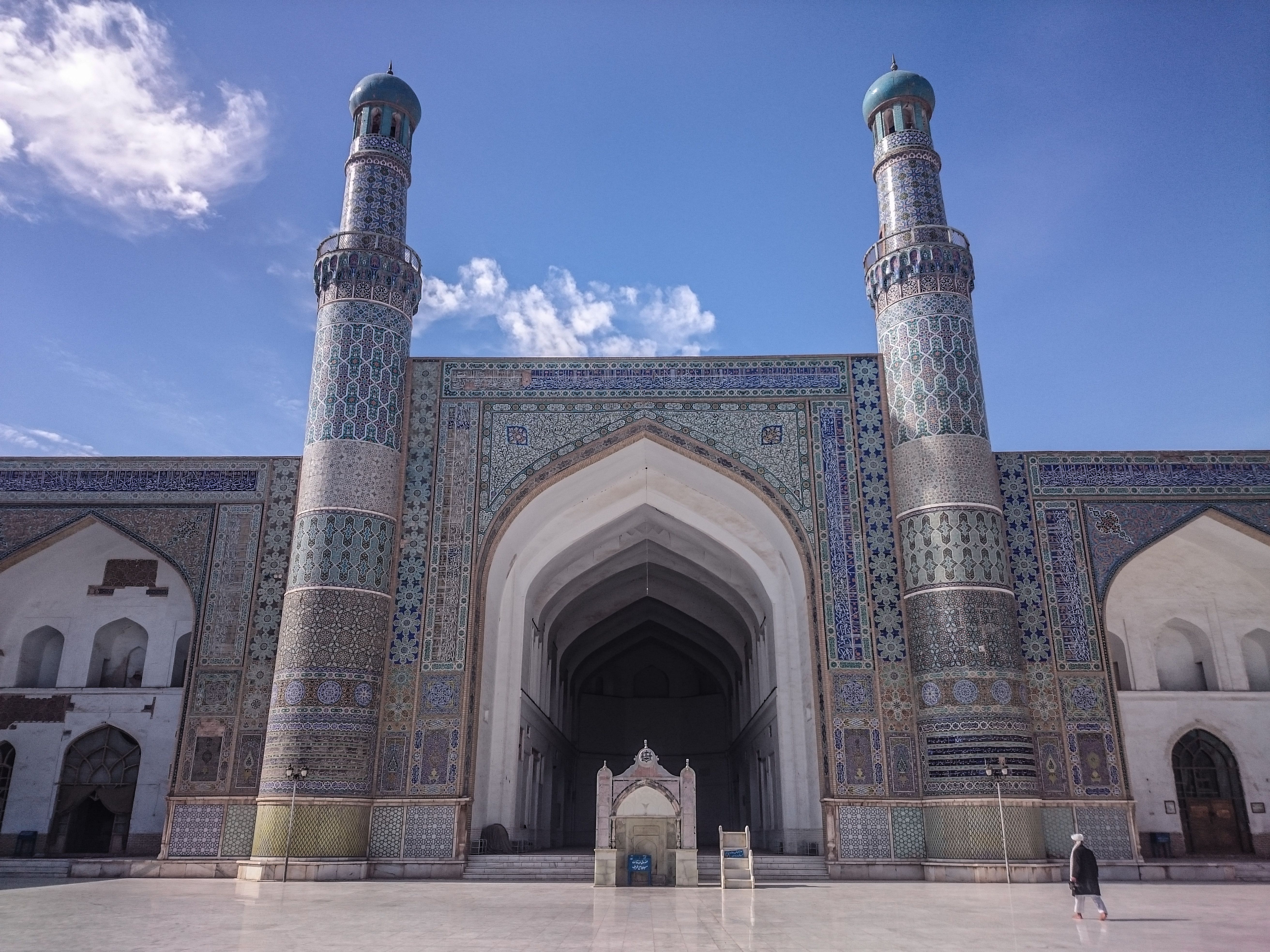 Impressive façade of the Great Mosque in Herat, Afghanistan, showcasing intricate Islamic architecture and blue sky backdrop.