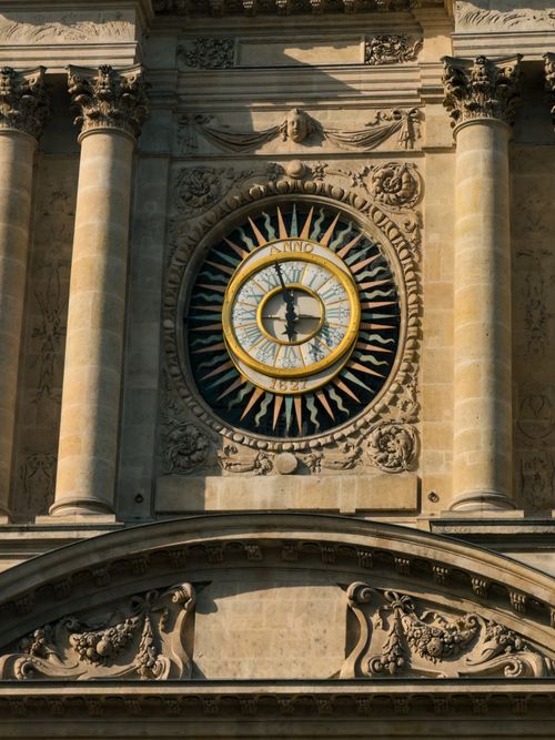 Free Close-up of a decorative old clock on a historic Paris building facade. Stock Photo