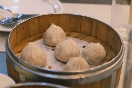 Close-up of steamed dumplings in a traditional bamboo basket, ready to serve.