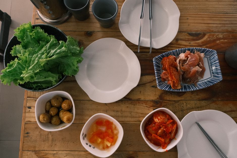 Photo by John Joshua Mejia Jose on Pexels A top view of a traditional Korean meal with vegetables, kimchi, and potatoes on a wooden table. - Photo by John Joshua Mejia Jose on Pexels