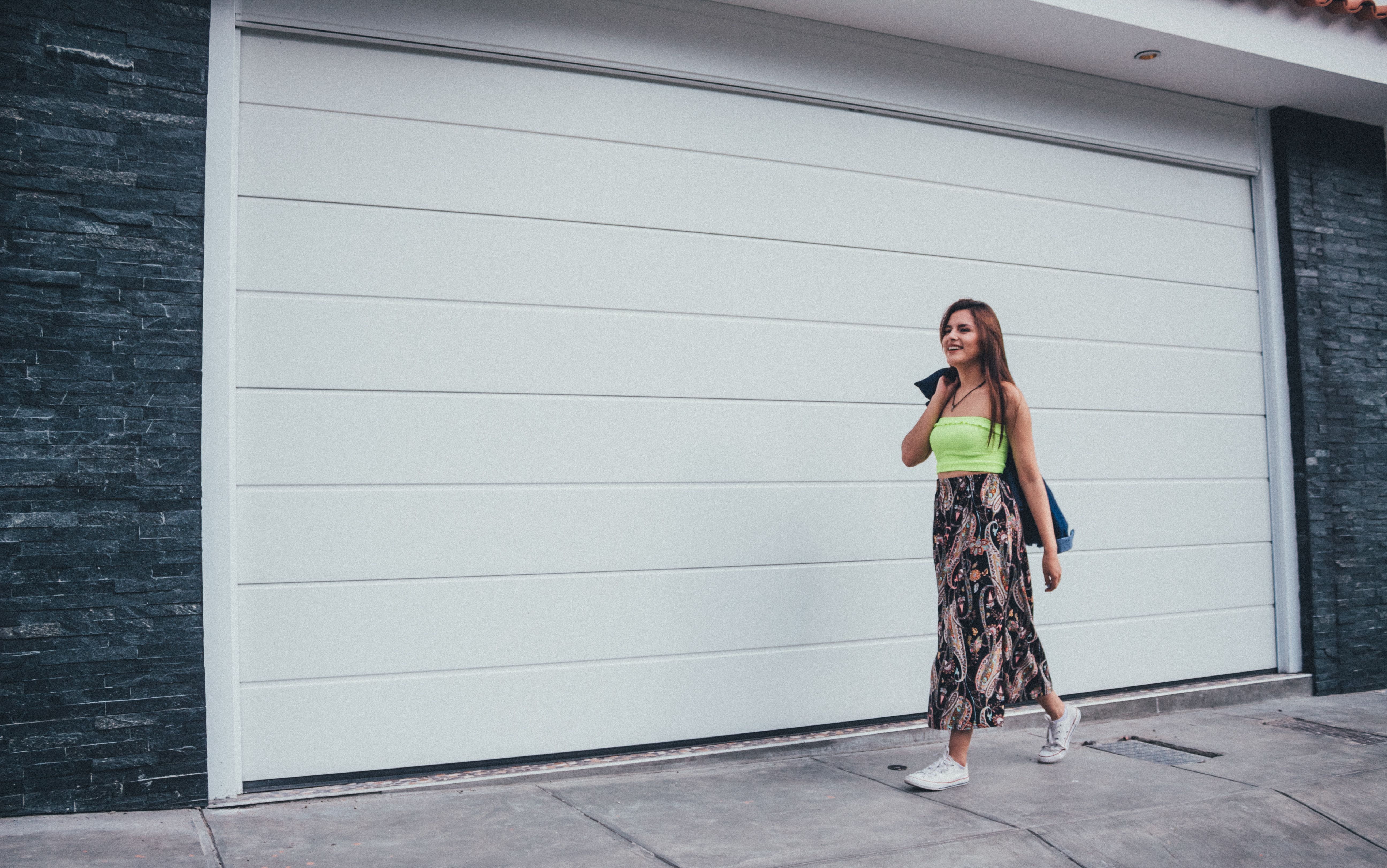 Photo of Woman Walking Beside White Wall · Free Stock Photo