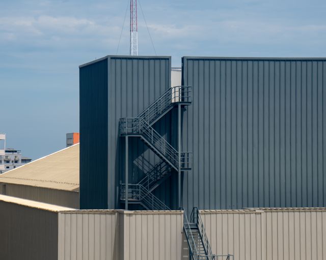 Commercial rooftop access Commercial building rooftop with an outside metal staircase under a clear sky