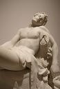 Classic stone sculpture of resting male