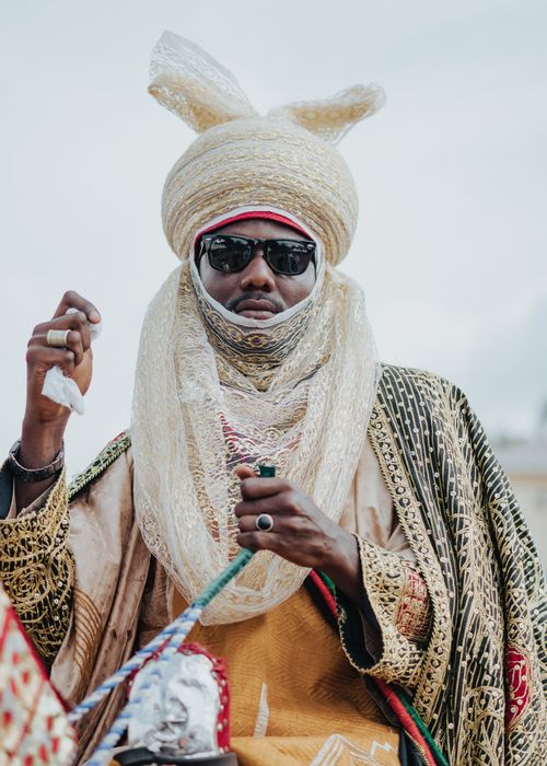 Free African man dressed in traditional attire and ornate turban with sunglasses, exuding cultural elegance. Stock Photo