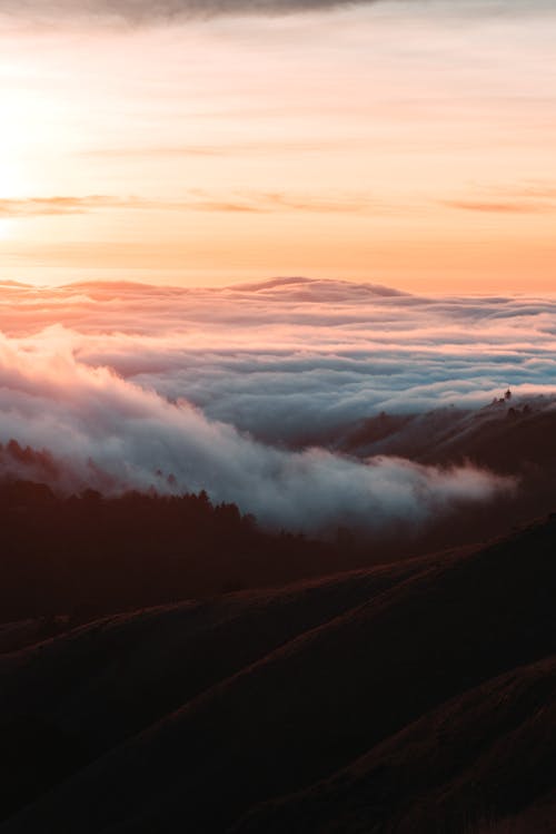 厚厚的雲層在山下的夕陽的天空下