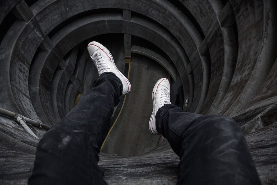Como Enfrentar o Medo de Morrer e Viver com Coragem 2 View from above looking down into a circular structure with legs in black jeans and white shoes.