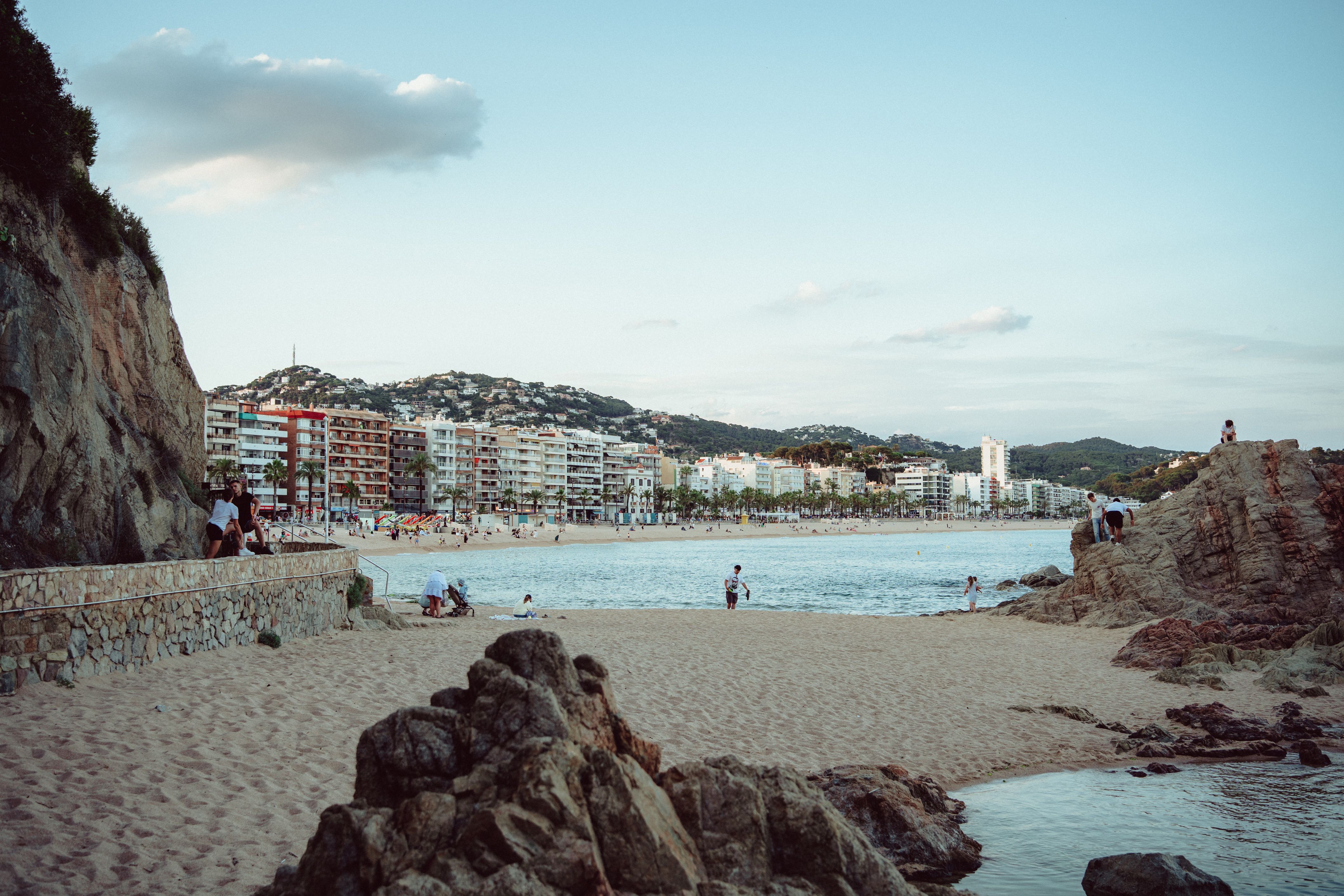 Beautiful beach scene with coastline and people at Lloret de Mar, Spain.