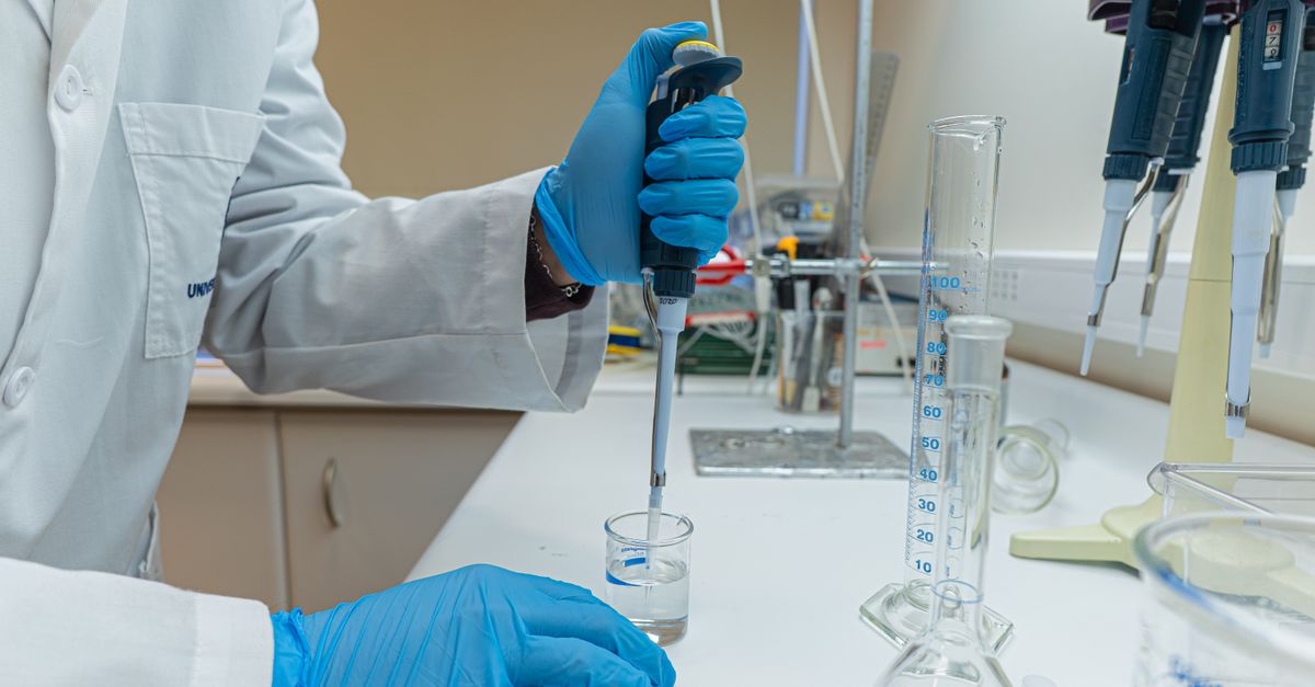 Lab scientist using pipette in chemical experiment with precision.