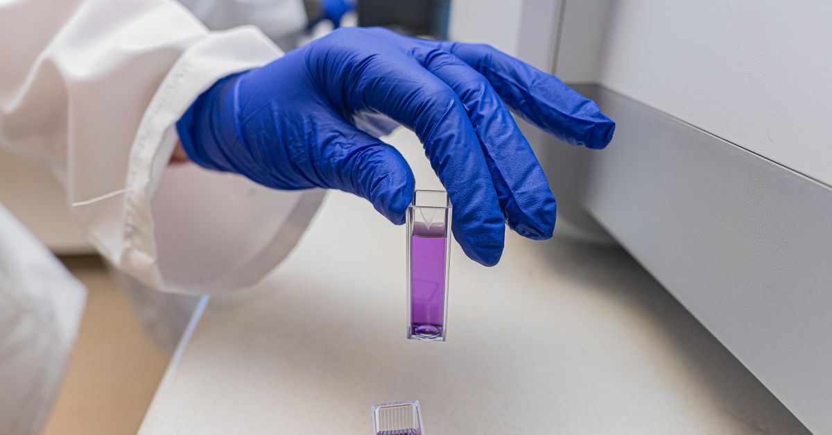 Scientist handling a laboratory sample vial