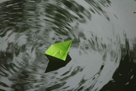 A green paper boat drifting on rippling water — photo by Jahra Tasfia Reza on Pexels