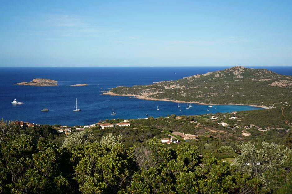 Beautiful panoramic view of Sardinia's coastline with clear blue waters and lush greenery.