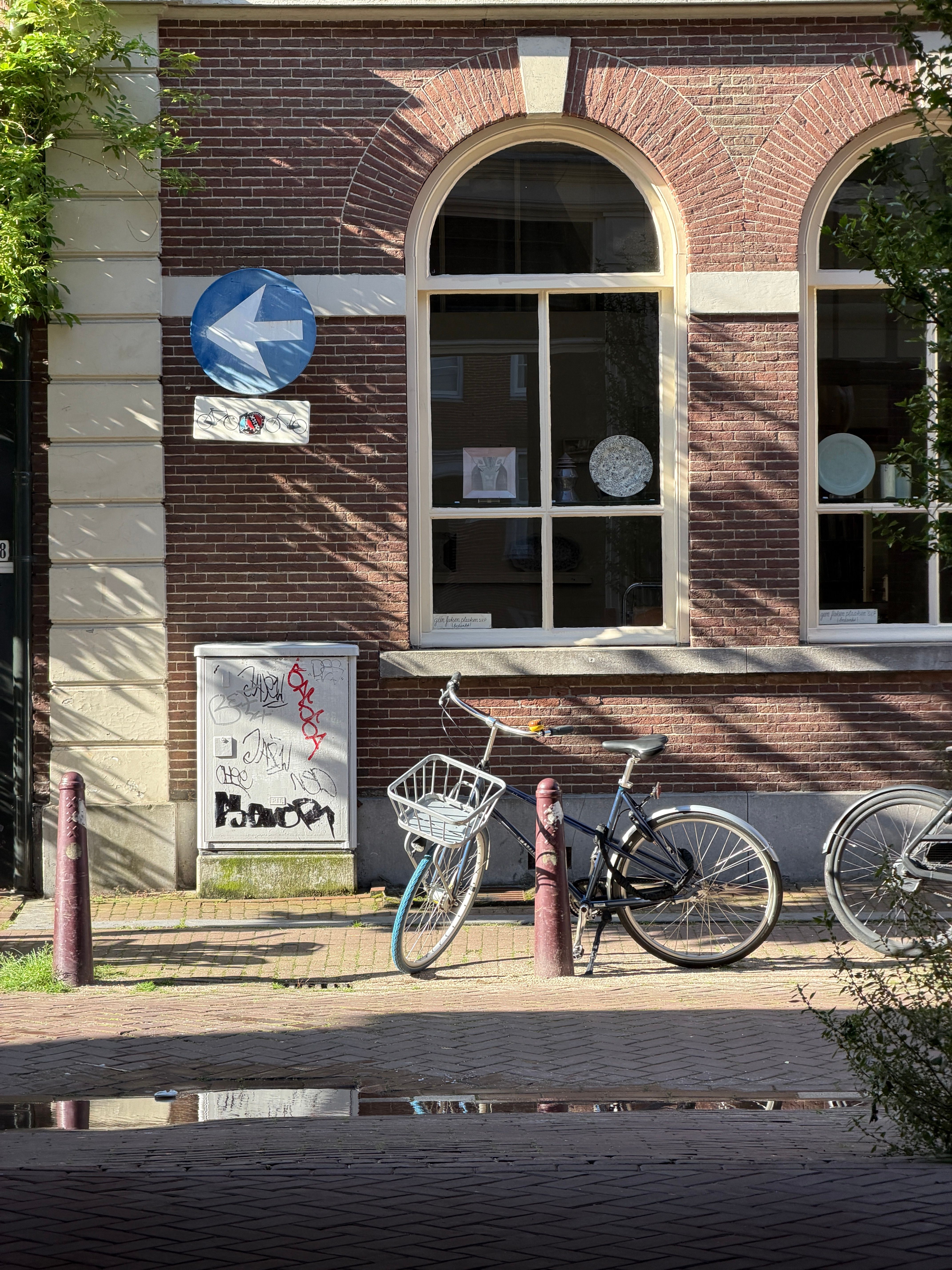 Quintessential Amsterdam scene featuring bicycles parked against a classic brick building.