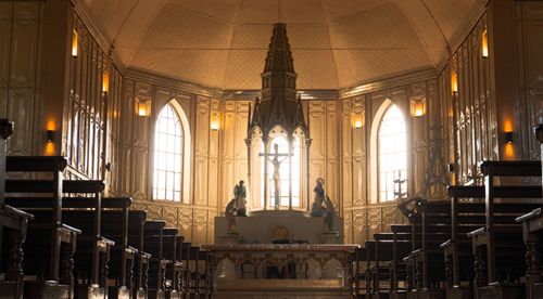 Free Atmospheric interior of a historic church with ornate altar and statues. Stock Photo