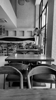 Modern cafe interior with wooden furniture and large windows in Bengaluru, India.