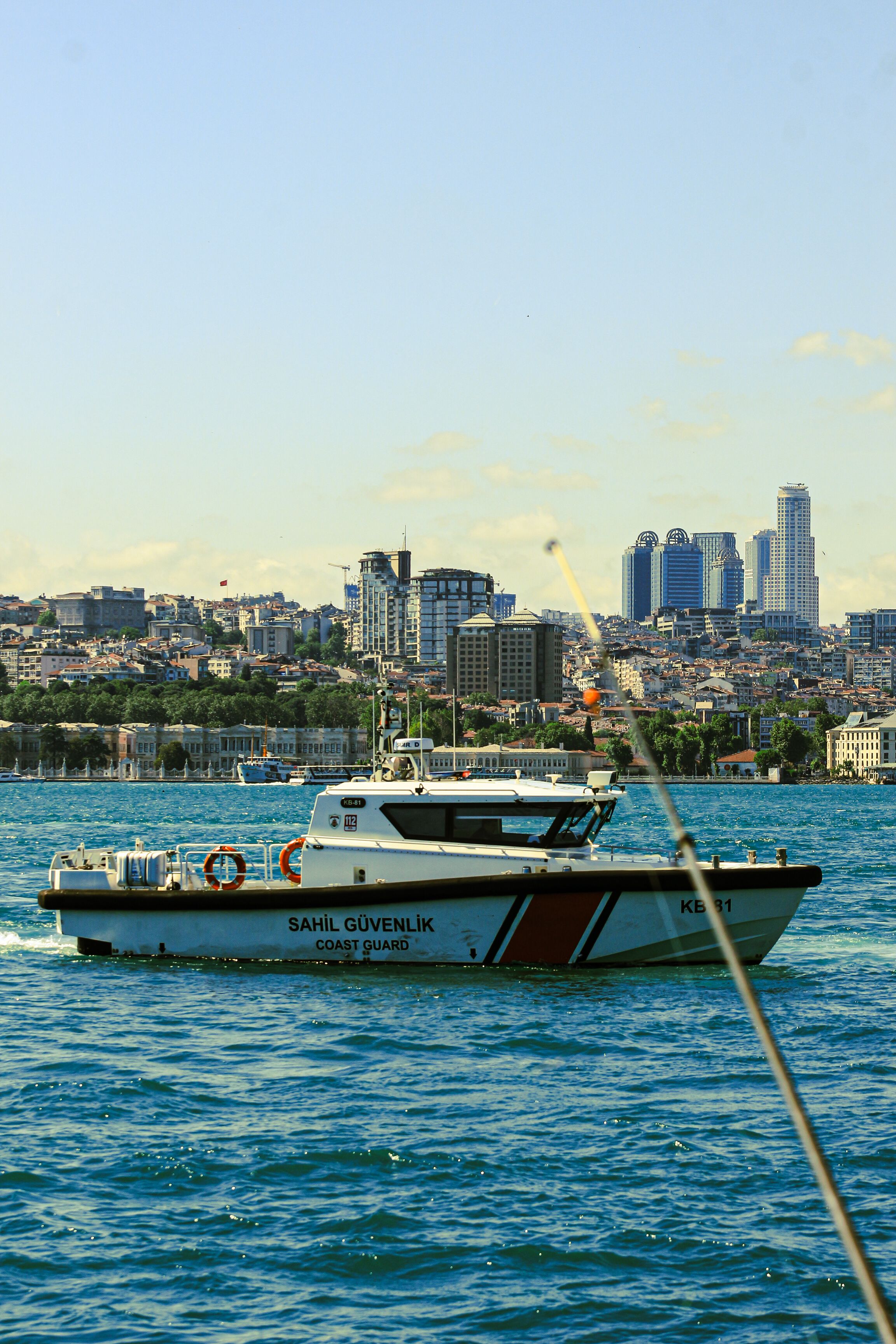 Coast Guard boat on the Bosphorus in Istanbul with city skyline background.