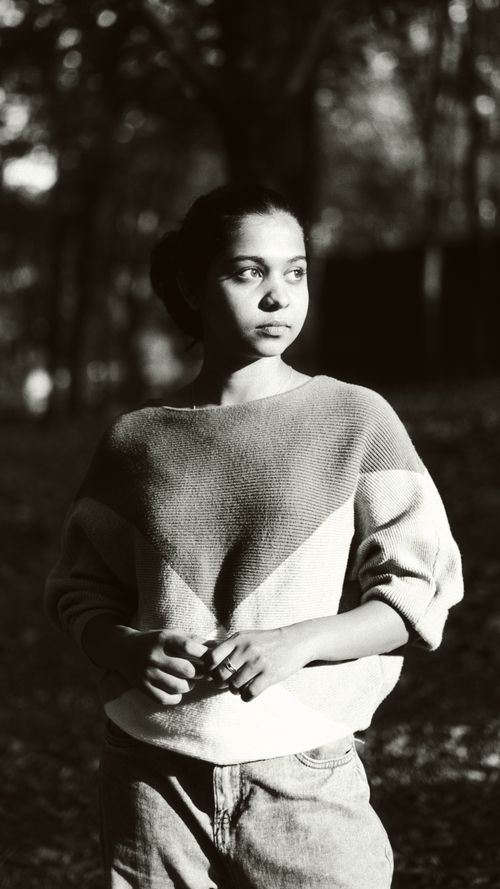 Free Artistic black and white portrait of a woman in a serene, wooded environment. Stock Photo