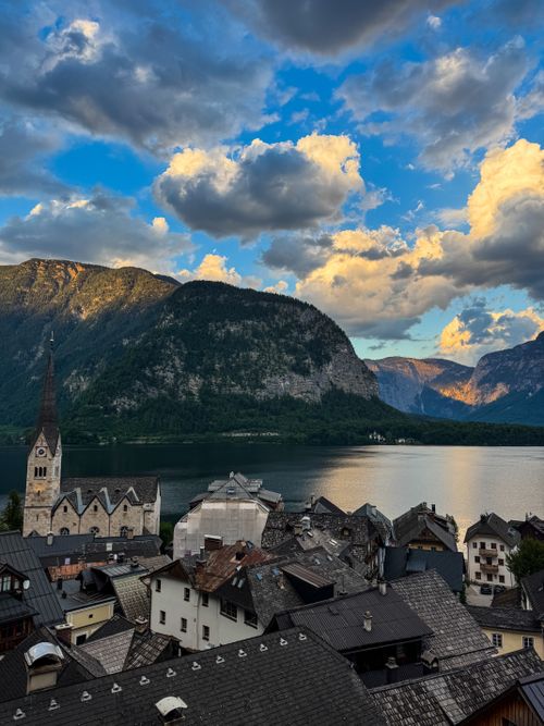 Free Breathtaking view of Hallstatt village with church, lake, and mountains under a dramatic sky. Stock Photo