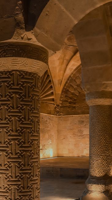 Fotomural Intrincadas columnas de piedra en un entorno subterráneo histórico, que muestran un arte ancestral.