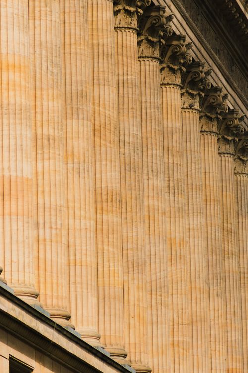 Fluted stone columns along a classical facade — photo by Ch Jawad on Pexels