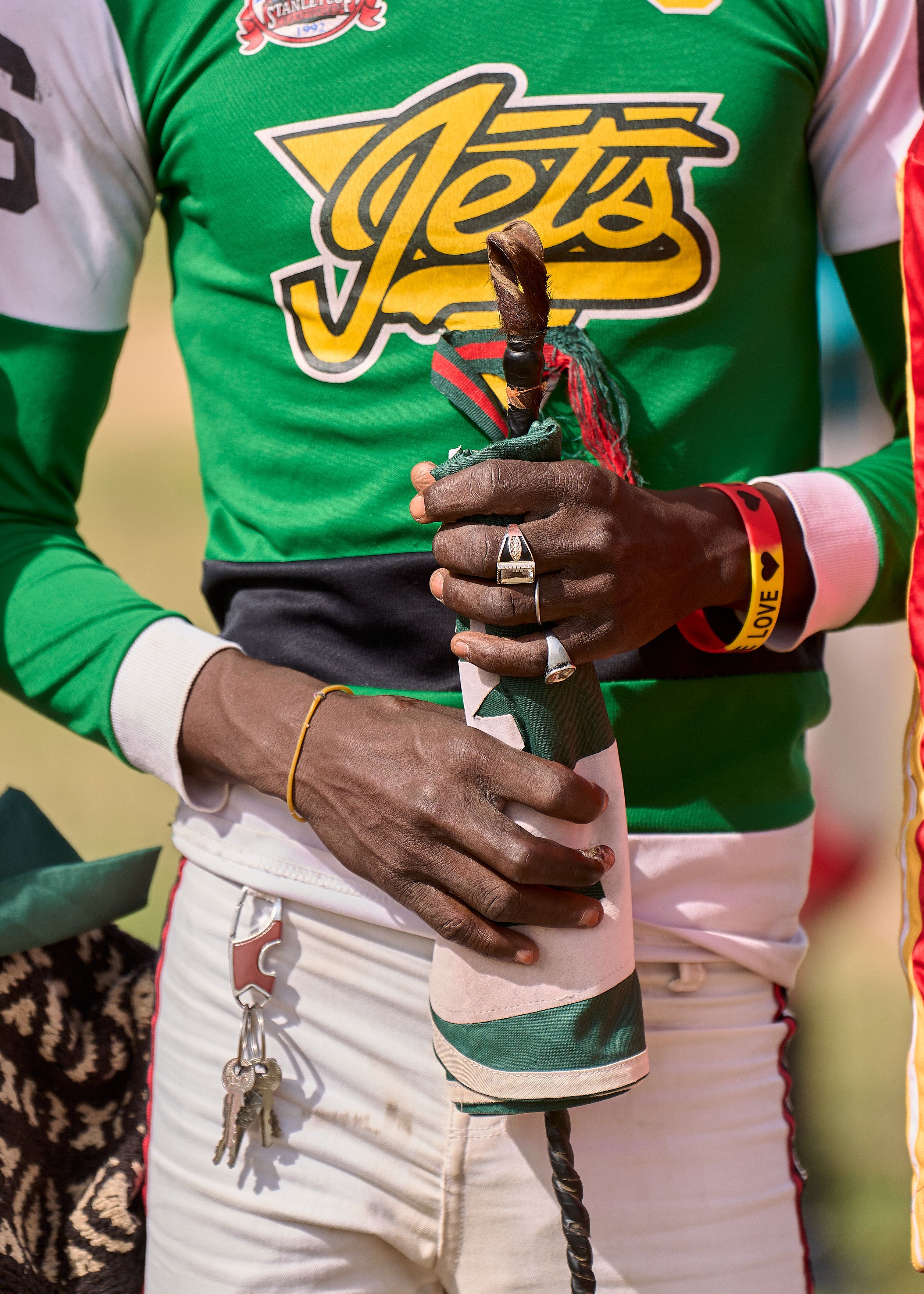 A man in colorful attire holding a traditional sword in Zaria City, Nigeria.