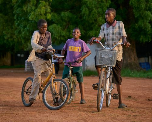 Free Three young boys enjoy riding bicycles outdoors in Zaria, Nigeria. Stock Photo