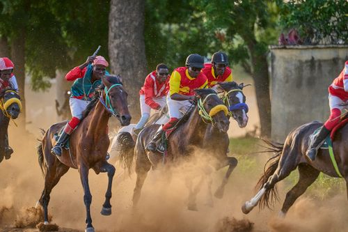 Free Dynamic horse racing scene with jockeys competing fiercely in Zaria City, Nigeria. Stock Photo