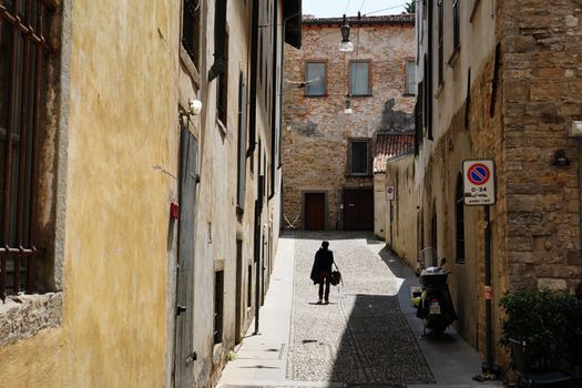 Charming street scene with cobblestone alley in Bérgamo, Italy, capturing historical architecture.