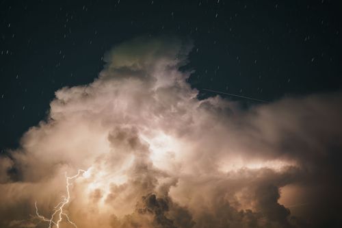 Free A captivating night sky with dramatic lightning illuminating large thunderstorm clouds. Stock Photo