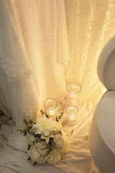 Soft lighting on wedding decor with candles and floral arrangement, creating a romantic ambiance.