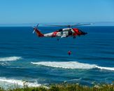 Dramatic coast guard helicopter rescue operation over the ocean waves.