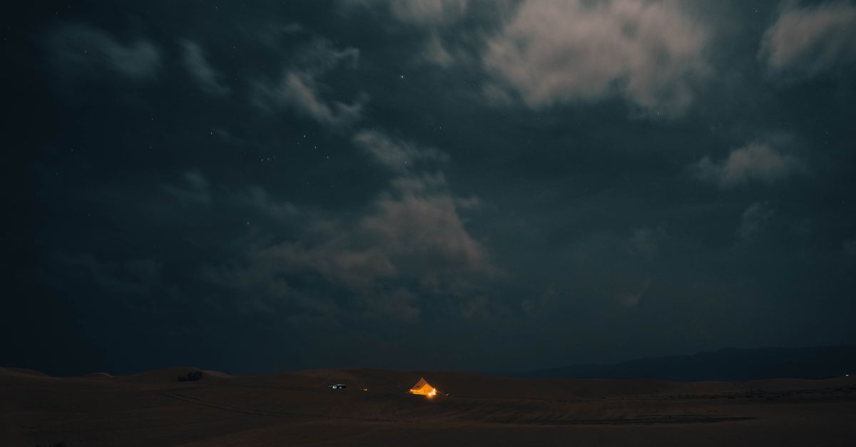 Illuminated tent under a star-filled night sky in the desert — the overnight camp experience on the 2 days to Zagora desert tour