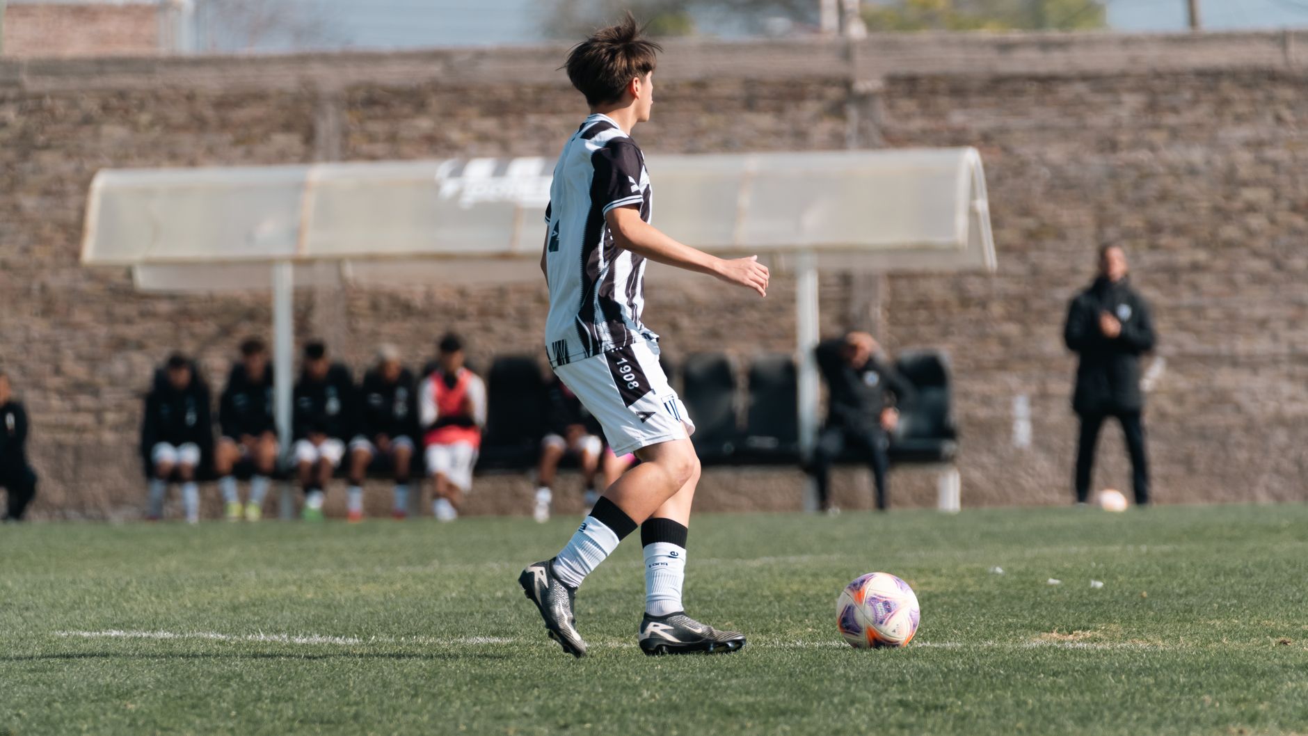 A young soccer player in action on a green field during a match.