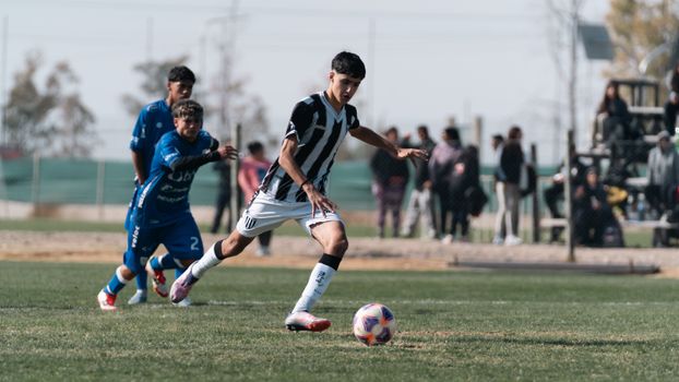 Dynamic scene of young soccer players competing intensely on a sunny field, showcasing athletic determination.