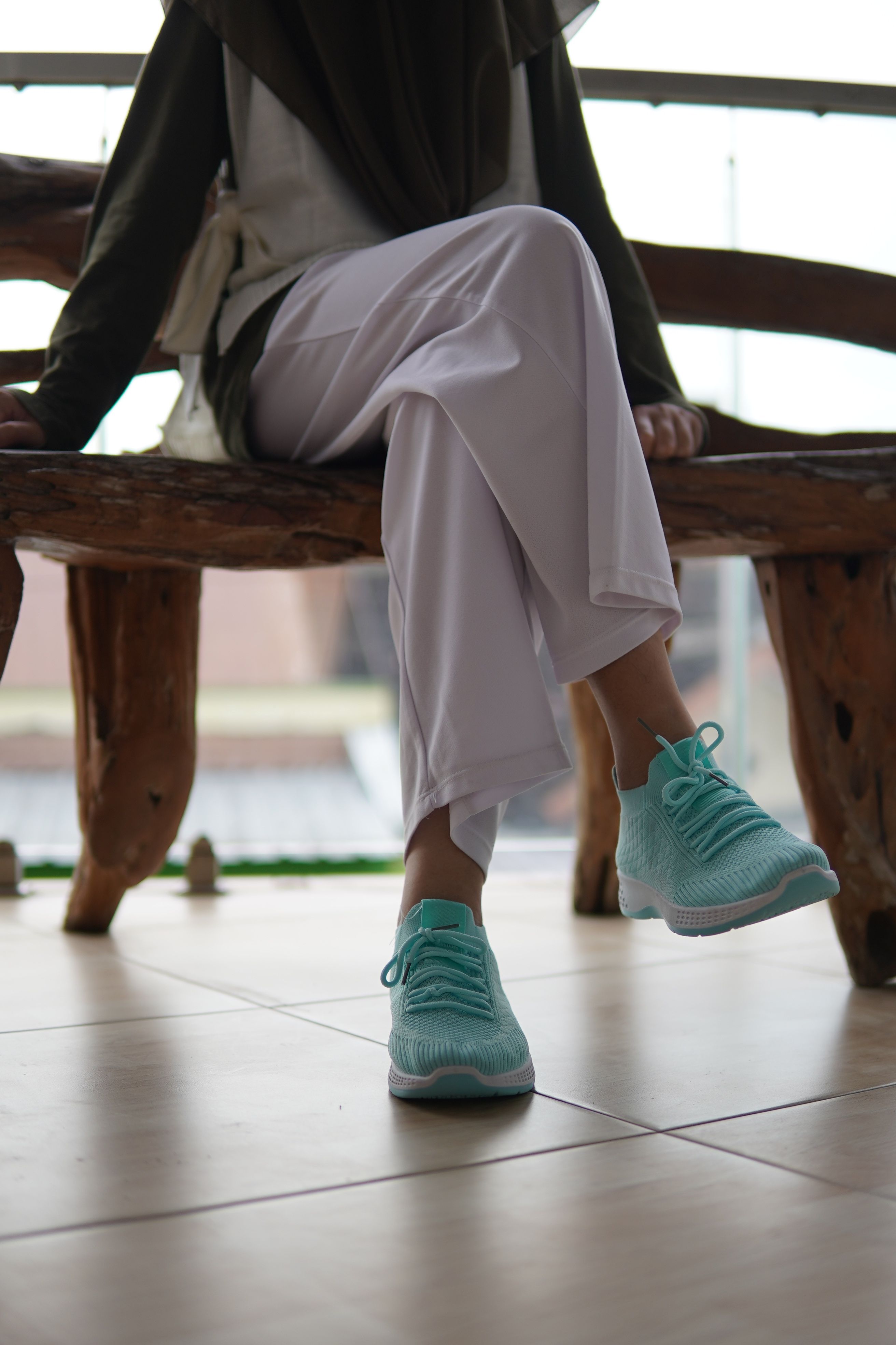 Casual Woman Sitting with Turquoise Sneakers