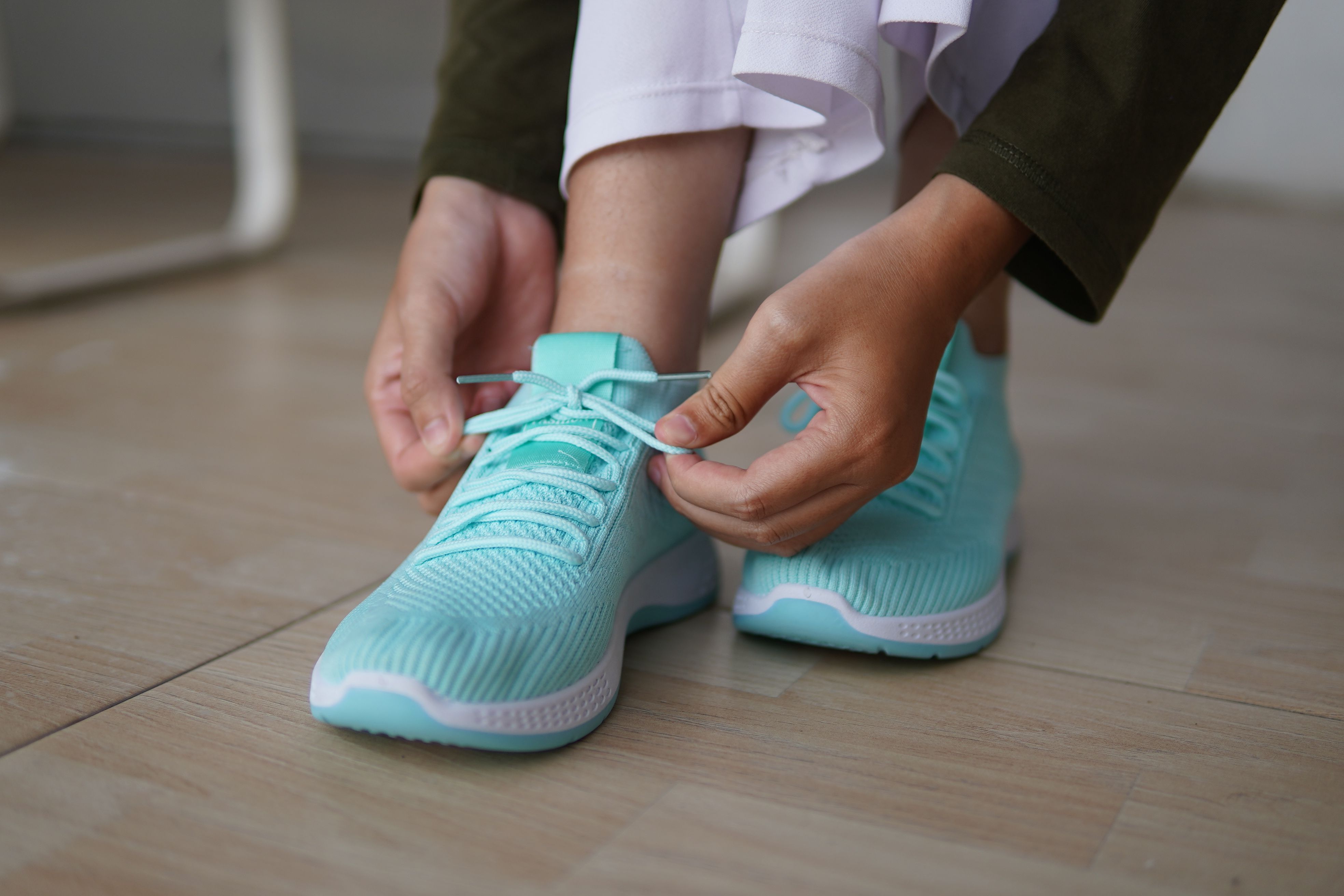 Close-up of a Person Tying Turquoise Sneakers