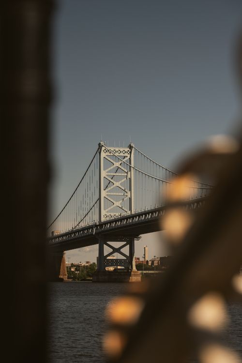 Free Artful view of the Benjamin Franklin Bridge captured through a foreground with a focus on its architecture. Stock Photo