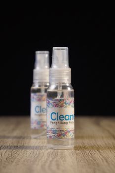 Two plastic spray bottles on a wooden surface, suitable for cleaning or hygiene product presentations. - Fotografer Sidoarjo