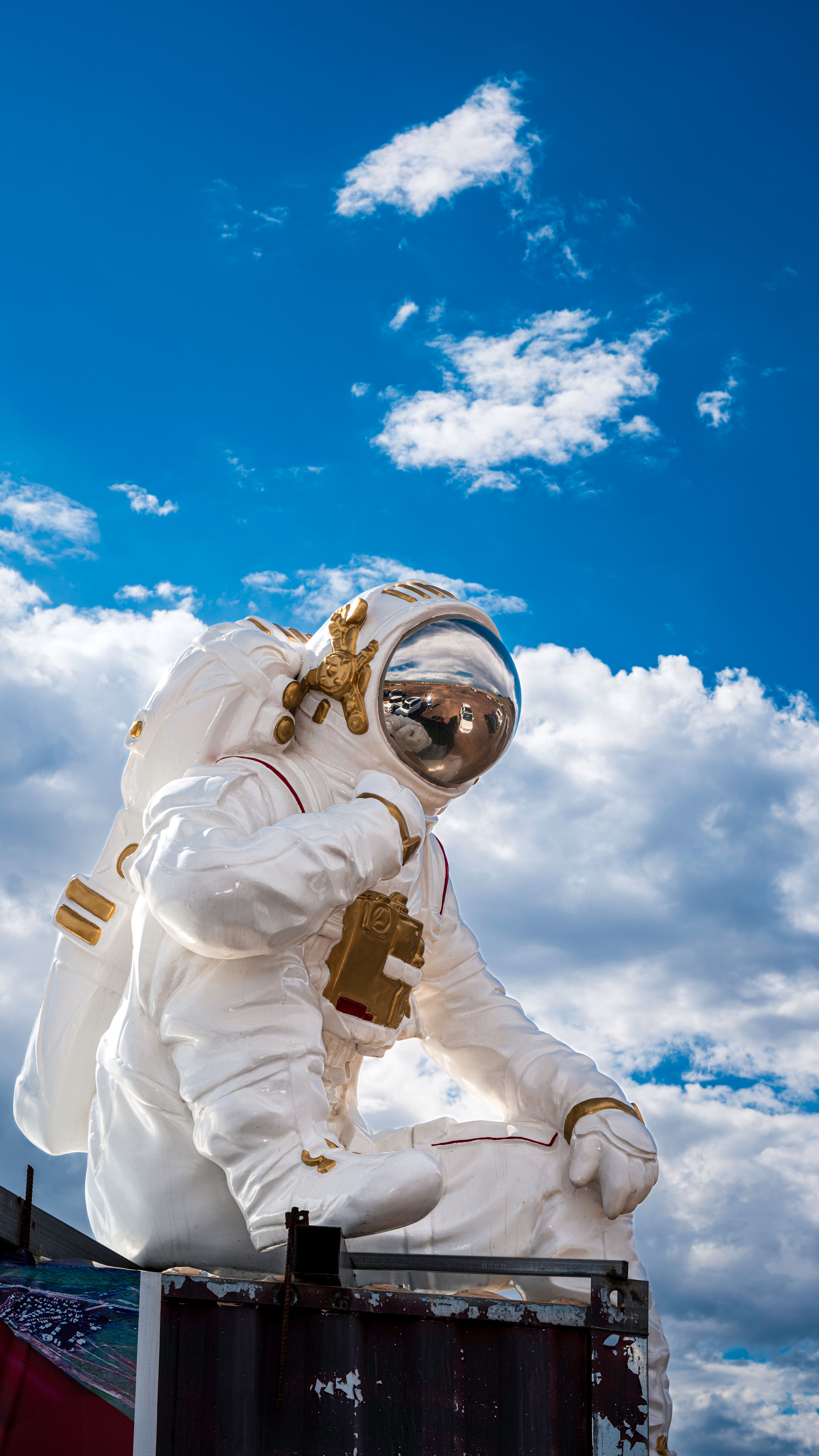 Impressive giant astronaut sculpture set against a vivid blue sky.