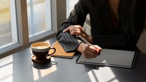 Person in Black and White Pinstripe Dress Shirt Using Tablet Computer