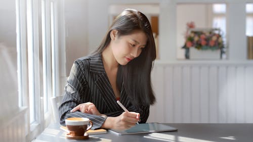 Woman in Gray and White Pinstripe Dress Shirt Using Black Tablet Computer
