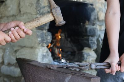 Hammer raised beside a live fire — photo by Tahir Xəlfəquliyev on Pexels